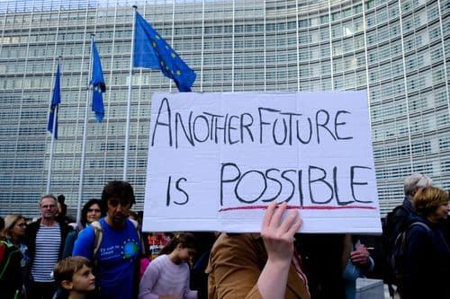 Protesta ante el Parlamento Europeo. En primer término se ve en ucartel hecho a mano que poner: "Another future is possible"