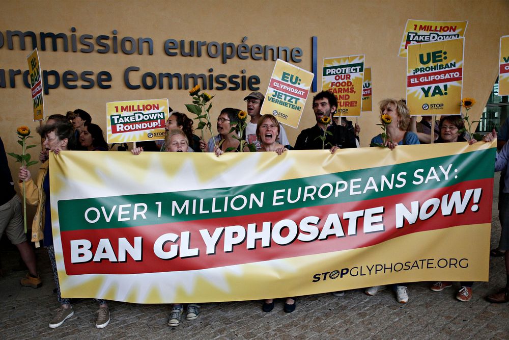 Activisten die achter een spandoek staan met de tekst "Verbied glyfosaat nu!"