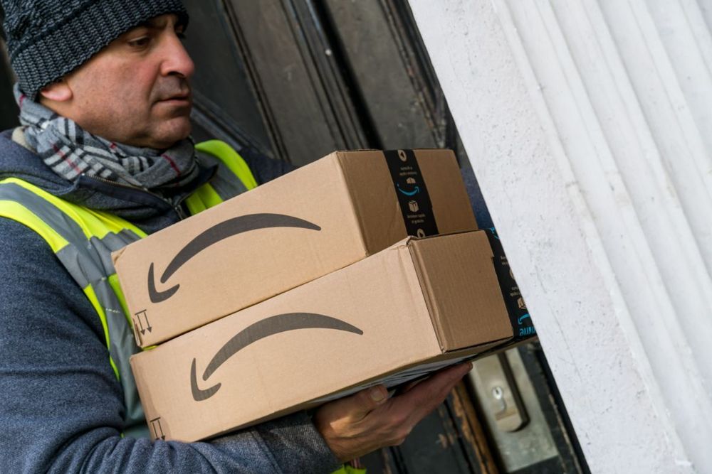 a photo of an Amazon worker holding packages